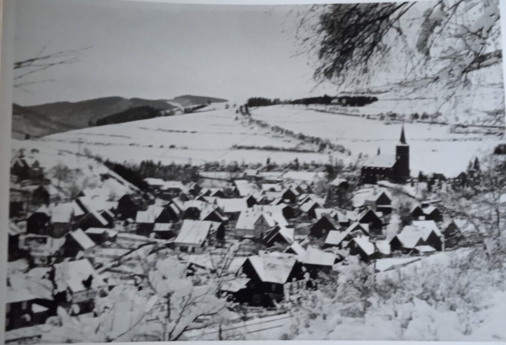 Blick auf das verschneite Züschen und den Kreuzweg am Hackelberg